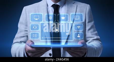 Webinar, banner design. Man using tablet on dark blue background, closeup. Virtual screen with icons over device Stock Photo