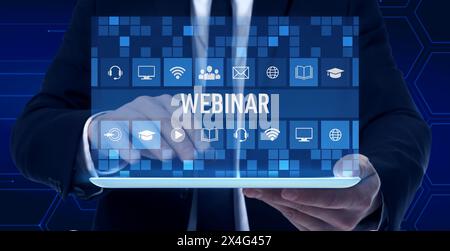Webinar, banner design. Man using tablet on dark blue background, closeup. Virtual screen with icons over device Stock Photo