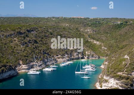 Bonifacio, Corse-du-Sud, Corsica, France. View over the harbour from hillside, yachts moored in cove beneath limestone cliffs. Stock Photo