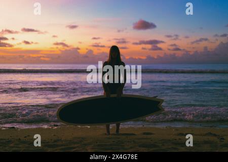 Full length portrait of beautiful woman standing with surfboard Stock Photo