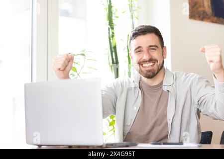 man with beard working in home office and making winner signs Stock Photo