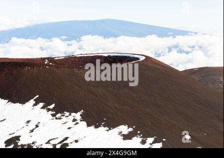 Hawaiian snow-capped volcanic crater above the clouds Stock Photo