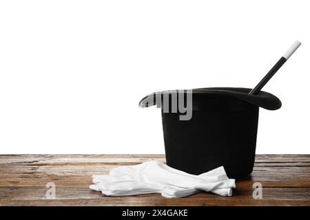 Magician's hat, gloves and wand on wooden table against white background Stock Photo