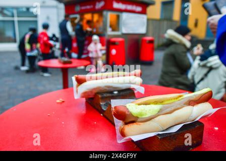 Reykjavik, Iceland - march 15th, 2023: Close up traditional tasty hotdogs and customers by stand in line downtown Reykjavik.Famous traditional iceland Stock Photo