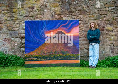 Haddington, Scotland, UK. 3rd  May 2024. Landscape artist Joe Grieve displays his paintings at Colstoun House near Haddington. His exhibition marks the opening of the first exhibition of Colstoun Arts which a new venture, partly about diversification and new ways to sustain a country house, and partly about starting the journey to their vision – to become a national museum for landscape art. Pic; artist Joe Grieve beside  painting The Law .  Iain Masterton/Alamy Live News Stock Photo