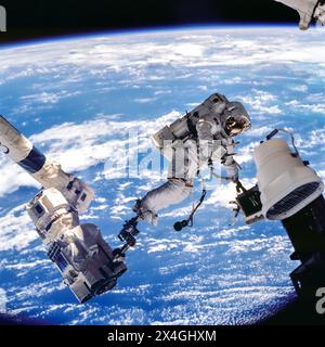 ASTRONAUT WOLF, DAVID-A. STS-112 MISSION SPECIALIST, ANCHORED TO A FOOT RESTRAINT ON SPACE STATION REMOTE MANIPULATOR SYSTEM (SSRMS) OR CANADARM2, CARRIES THE STARBOARD ONE OUTBOARD NADIR EXTERNAL CAMERA. Stock Photo