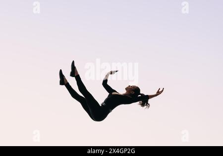 Woman getting trapped in the digital world, drowning in the vastness of the world wide web. She is immersed in endless scrolling on her smartphone. Stock Photo