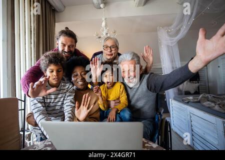 Extended multiethnic family together at home during video call. People happiness technology concept Stock Photo