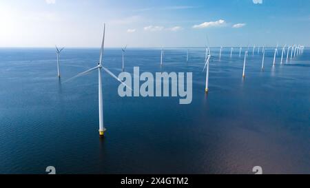 A vast expanse of wind turbines scattered across the ocean, their ...