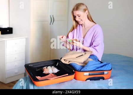 girl packing suitcase cosmetics packaging for airplane for hand luggage Stock Photo