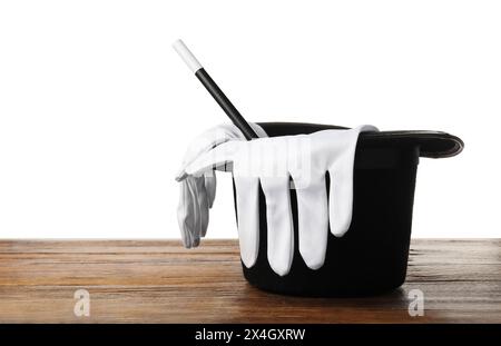 Magician's hat, gloves and wand on wooden table against white background Stock Photo