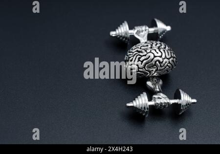 Creative brain workout concept. Steel copy of a human brain training with weights isolated on black. Stock Photo