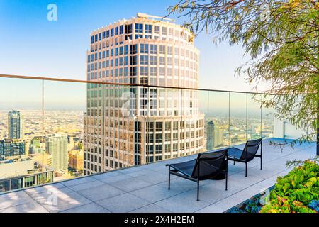 Elevated view of the top floors of the iconic skyscraper in downtown Los Angeles seen from a stylish balcony, complete with two chairs and a glass bar Stock Photo