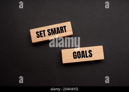 Set smart goals written on wooden blocks with black background. Conceptual set smart goals symbol. Copy space. Stock Photo