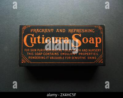Circa. 1910 – An antique box made to contain Cuticura Soap, dating from the early 20th century. The box is decorated with a bold black and orange design which incorporates the slogan, “Fragrant and Refreshing Cuticura Soap For Skin Purification, The Toilet, Bath and Nursery – This Soap Contains Emollient Properties Rendering it Valuable For Sensitive Skins”. Founded in 1865, Cuticura soap was originally manufactured in Boston, Massachusetts by Potter Drug and Chemical Corporation. Stock Photo