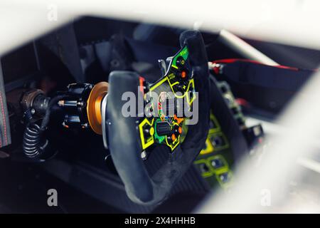Detailed view of a high-tech racing car steering wheel, gear shift controls and settings. Interior professional race car drivers technology Stock Photo