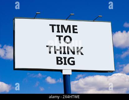 Time to think big symbol. Concept words Time to think big on beautiful big white billboard. Beautiful blue sky cloud background. Business and time to Stock Photo