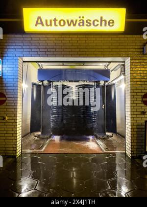 View of car wash at night with rotating brushes textile brushes for automatic machine car wash above illuminated sign with lettering car wash, Germany Stock Photo