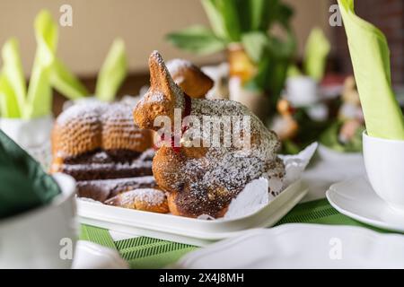 Easter lamb cake dusted with powdered sugar on a table with green accents and spring decor Stock Photo