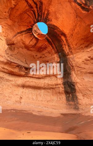 Big Hogan Arch in Monument Valley Arizona lies in a remote area of the park and is unique due to its eroded sandstone on the ceiling of the arch, maki Stock Photo