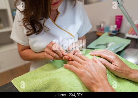 Close-up of a manicure where a nail file is being used on a client's fingernails Stock Photo