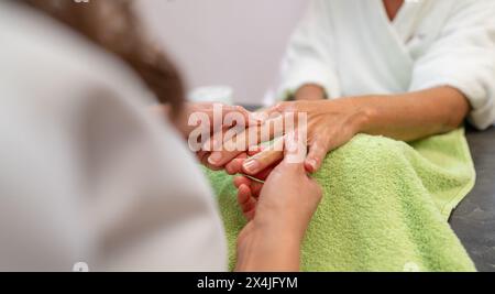 Manicurist massaging womans hand during a manicure session in a beauty salon. body care spa treatment concept image Stock Photo