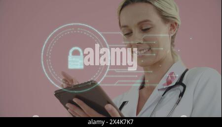 Image of digital interface online security padlock over smiling female doctor using digital tablet Stock Photo
