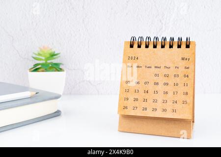 May 2024, Monthly desk calendar for 2024 year on the table with diary. Stock Photo