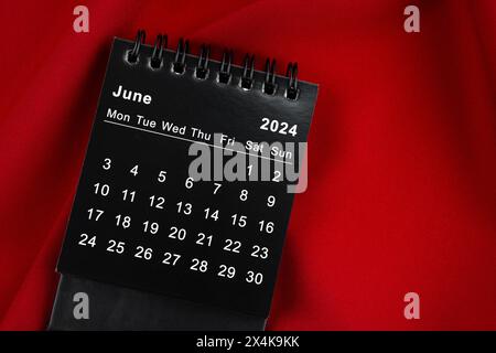 June 2024 Black spiral desktop calendar and wooden pencil on yellow ...