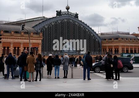 Madrid, Spain. February 11, 2024 - Group of People Standing in Front of Historic Atocha Train Station. Stock Photo