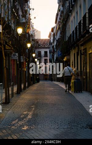 Madrid, Spain. February 11, 2024 - Two people rolling suitcases on the streets of Madrid, Spain in the evening. Stock Photo