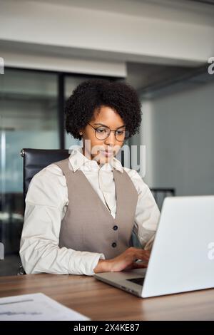 Young African American female employee using laptop working in office. Stock Photo