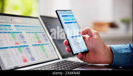 Man Using Spreadsheet Data On Laptop Computer Stock Photo