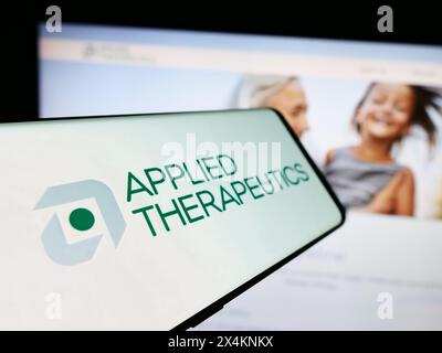 Cellphone with logo of American biopharmaceutical company Applied Therapeutics Inc. in front of website. Focus on center-left of phone display. Stock Photo