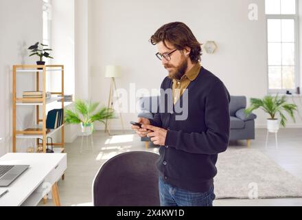 Man uses smartphone to work, read news, chat, shop online or search for information on Internet. Stock Photo