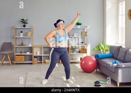 Overweight, obese woman doing physical exercises indoors at home Stock Photo