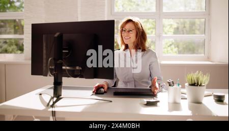 Employee Working On Desktop Computer In Home Office Stock Photo