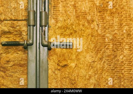 Metal deadbolt on a door or gate covered with wooden cardboard Stock Photo