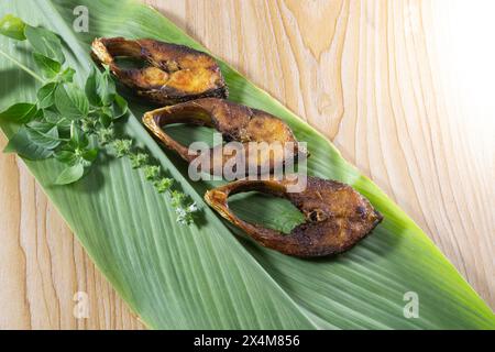 Fried Ilsha on Turmeric leaf. Hilsa fry is popular in pohela boishakh festival among Bengali's in India and Bangladesh. Ilish. Tenualosa ilish Stock Photo