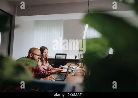 Business professionals collaborating on a project in a modern office setting Stock Photo
