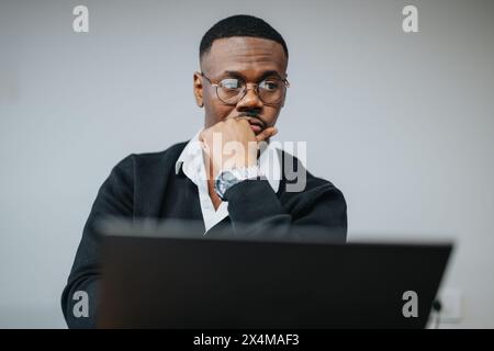 Focused African American businessman analyzing data on a computer in an office Stock Photo