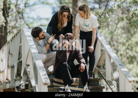 Group of diverse friends enjoying a fun conversation on park steps on a sunny spring day Stock Photo