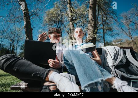 Students collaborating on homework in a peaceful park setting Stock Photo