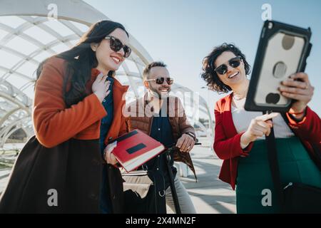 Business colleagues collaborating on a project outdoors using a tablet Stock Photo