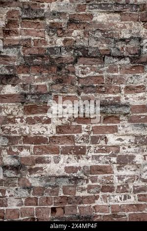 An old brick wall. Antique red brick background with white interlayer between bricks. Vertical Photo. High quality photo. Can be used for banner desig Stock Photo