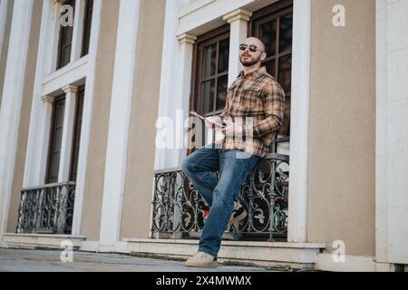 Young business professional holding documents standing in an urban city area Stock Photo