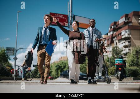 Diverse business team walking outdoors on a sunny city day, brainstorming ideas Stock Photo