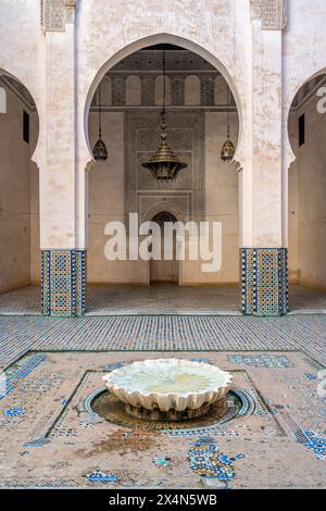 Tranquil courtyard featuring a traditional fountain with intricate tile work in Fez, Morocco. Stock Photo