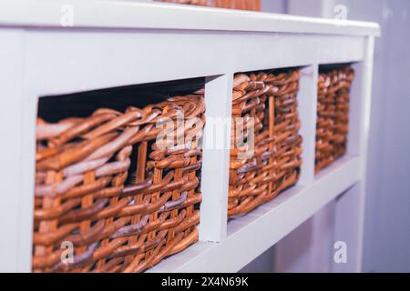 Wicker baskets on a shelf in a store, close-up Stock Photo
