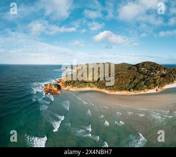 Byron Bay lighthouse and the pass high on the rocky headland - the most eastern point of Australian continent facing Pacific ocean in elevated aerial Stock Photo